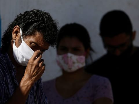 File photo: People wear masks as they wait for a quick COVID-19 test
