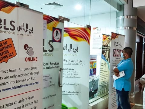 An information roll up outside BLS International in Deira advising applicants to book online appointments