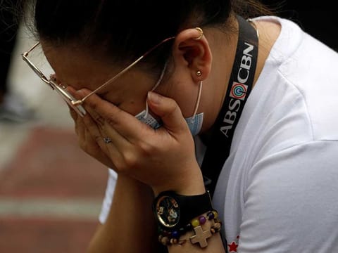 An ABS-CBN employee cries after the Philippine congress voted against the renewal of the broadcast network's 25-year franchise, outside ABS-CBN headquarters.