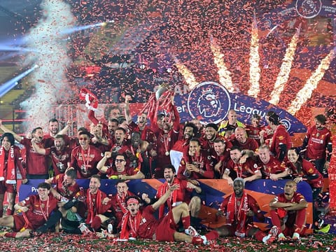 Liverpool's Jordan Henderson (C) and team-mates pose with the Premier League trophy during the presentation.