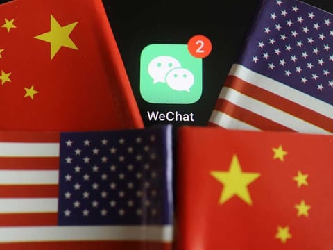 The messenger app WeChat is seen among U.S. and China flags.