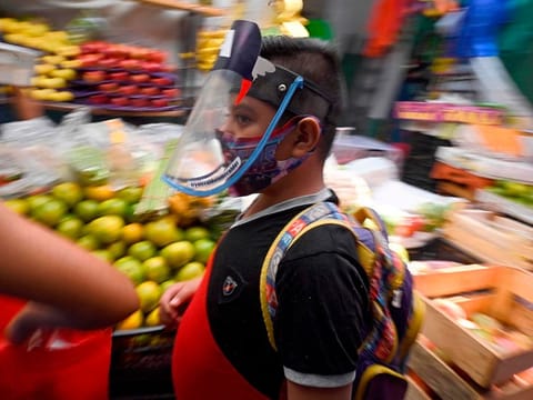 A boy wears a face mask at the San Cosme market in Mexico City on August 10, 2020 amid the COVID-19 novel coronavirus pandemic.