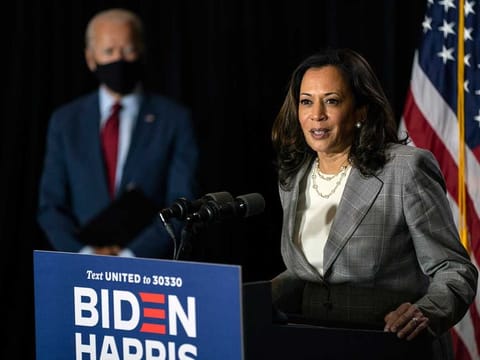 Democratic presidential candidate former Vice President Joe Biden stands left as his running mate Sen. Kamala Harris speaks at the Hotel DuPont in Wilmington, Delaware, Thursday, Aug. 13, 2020.