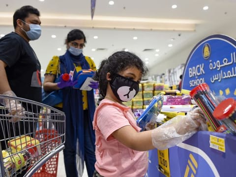 A family checks items at a Back to School promotion section at a hypermarket in Dubai.