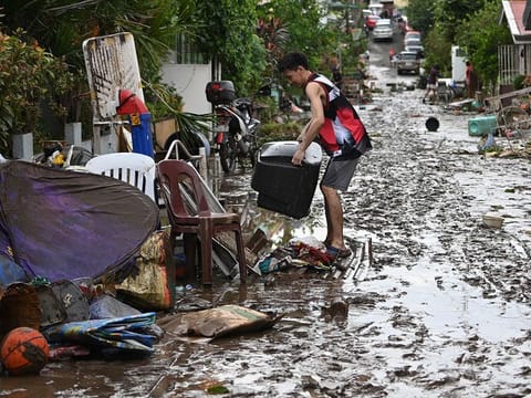 Residents clean their homes following flooding in Batangas City, south of Manila on November 2, 2020, after super Typhoon Goni made landfall in the Philippines on November 1.