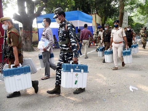 Security personal carrying VVPAT and EVM machines for polling booths from a distribution center ahead of the second phase of Bihar assembly elections, in Patna on Monday.
