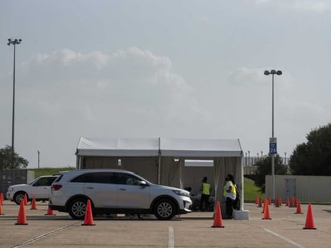 Voters drop off their ballots at a drive-through location for early voting for the 2020 Presidential elections in Houston on Oct. 13, 2020.