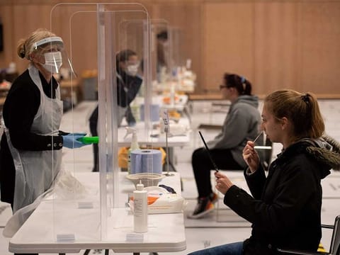 A student takes a swab for a lateral flow COVID-19 test on the first day of operation of new asymptomatic testing site in the University of Hull's Allam Sport Centre in Hull, northern England on November 30, 2020. The testing site is aiming to test asymptomatic university students during the first week of December in order to help them return home safely for Christmas. AFP