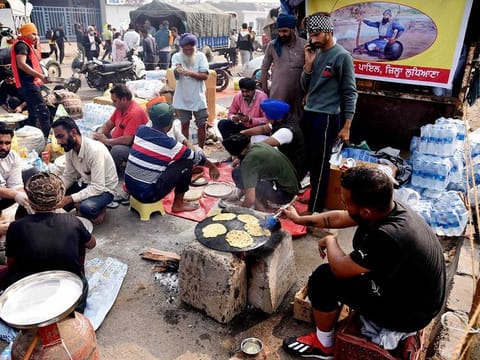 Farmers prepare food during their protest against the farm laws, at Singhu Border in New Delhi on Friday, December 4, 2020.