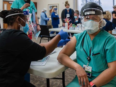 A nurse receives a COVID-19 vaccine at Providence St. Mary Medical Center in Apple Valley, Calif., Dec. 17, 2020.