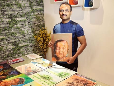 Dr Shaji Pallissery Kuzhiyil with some of his paintings.