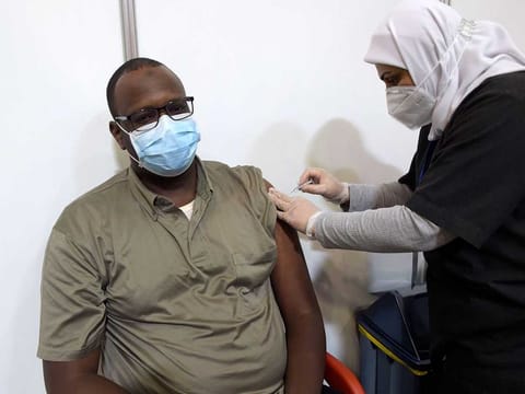 A man receives a COVID-19 vaccine at the Bahrain International Exhibition and Convention Centre in the capital Manama, on December 24, 2020.