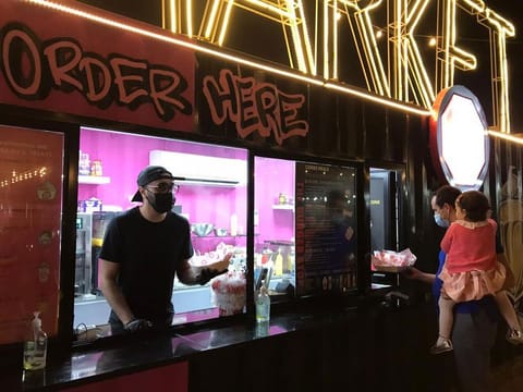 Shoayb Ajmal serving a customer at The Burger Joint at the Ripe Market in the Dubai Police Academy Park in Dubai.