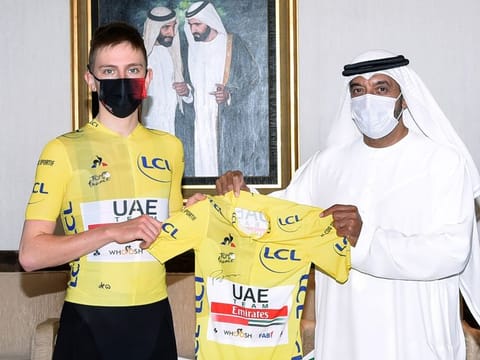 Sheikh Ahmad Bin Saeed Al Maktoum, Chairman and Chief Executive of Emirates Airline and Group, being presented the overall leader's yellow jersey by Tadej Pogacar on Thursday.