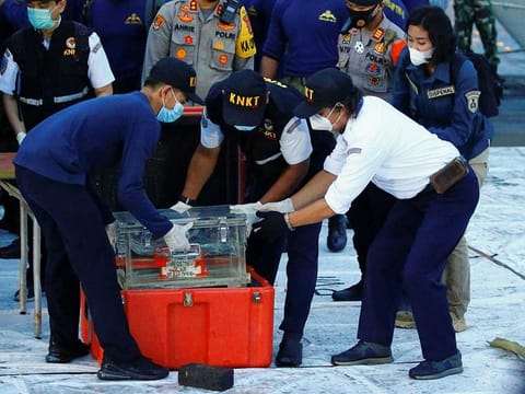 National Transportation Safety Committee (KNKT) officials hold a part of the retrieved black box of Sriwijaya Air flight SJ 182, which crashed into the sea off the Jakarta coast, in Jakarta, Indonesia.
