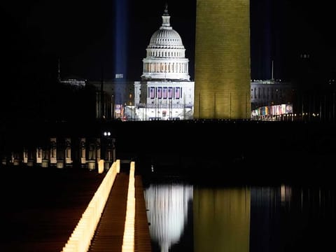 COVID-19 memorial lights surround the Reflecting Pool with the Washington Monument and the US Capitol in the background after the Celebrating America concert at the Lincoln Memorial in Washington