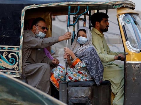 People with masks to fight against COVID-19 travel by rickshaw in Karachi, Pakistan January 25, 2021.
