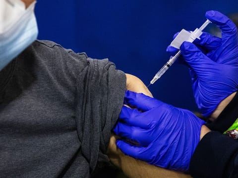 A pharmacist administers a dose of the Pfizer BioNtech COVID-19 vaccine at a mass vaccination site at Fenway Park in Boston, Massachusetts.