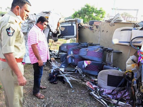 Police inspect the mangled remains of a mini bus after collided with a truck on the Hyderabad-Bengaluru national highway, near Veldurthi in Kurnool district of Andhra Pradesh, Sunday early morning. At least 14 people belonging to the same family were killed and four others were critically injured.