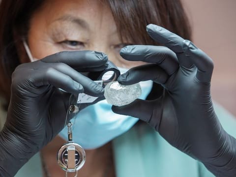 An employee shows a rare 242-carat rough diamond, which will be offered at the 100th international auction of Russian state-controlled diamond producer Alrosa, during a presentation in Moscow, Russia February 25, 2021. The diamond is one of the biggest gem-quality stones Alrosa has mined this century, the company said. Picture taken February 25, 2021.