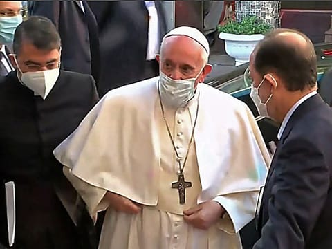 This grab from the official Iraqiya TV footage shows Pope Francis (C) arriving to meet Iraq's top Shiite cleric Grand Ayatollah Ali al-Sistani and is welcomed by his son Mohammad Reza Sistani (R) in the holy shrine city of Najaf on March 6, 2021.