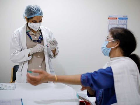 A woman watches as a healthcare worker fills a syringe with a dose of COVISHIELD, the coronavirus disease (COVID-19) vaccine manufactured by Serum Institute of India, at Max Super Speciality Hospital, in New Delhi, India, March 17, 2021.