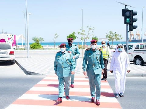 Officials use the pedestrian crossing on Khor Fakkan's Al Corniche Road.