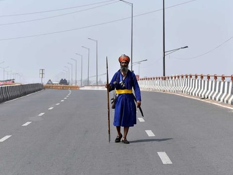 A Nihang Sikh walks on the deserted road at Ghazipur border (Delhi-UP border) in view of a 12-hour 'Bharat Bandh' call by Samyukt Kisan Morcha against Centre's Farm Laws, in New Delhi on Friday, March 26, 2021.