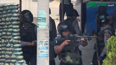 This screengrab provided via AFPTV and taken from a broadcast by Myitkyina News Journal on March 27, 2021 shows a policeman aiming his weapon as security forces stage a crackdown on demonstrations by protesters against the military coup in Myitkyina in Myanmar's Kachin state.