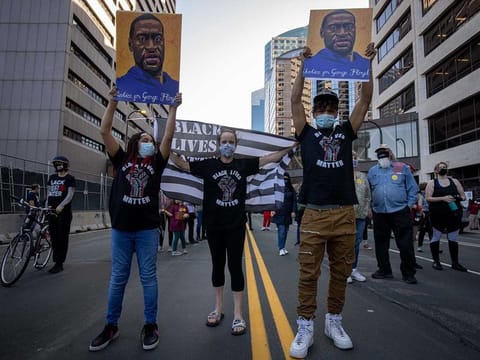 Demonstrators hold up images of George Floyd during a protest outside the Hennepin County Government Center in Minneapolis, Minnesota, US. Meanwhile, a Texas sheriff fired seven officers who had been put on administrative leave after the custody death of a Black man, Marvin D. Scott III.