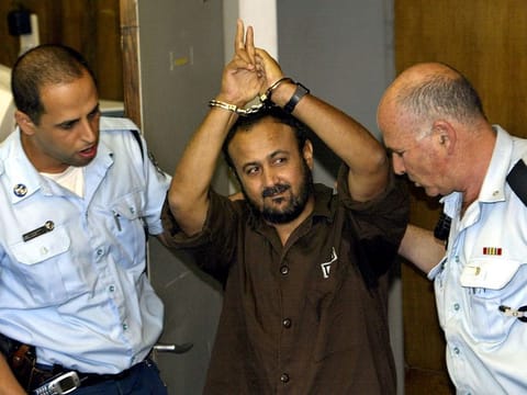Marwan Barghouti, a popular Palestinian leader, gestures as Israeli police bring him into the District Court for his judgment hearing in Tel Aviv May 20, 2004.