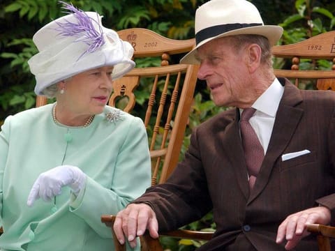 In this file photo taken on July 17, 2002 Britain's Queen Elizabeth II (L) and Britain's Prince Philip, Duke of Edinburgh (R) chat while seated during a musical performance in the Abbey Gardens, Bury St Edmunds, during her Golden Jubilee visit to Suffolk, east of England.