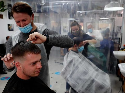 People get their hair cut at a busy hairdressers in London, Monday, April 12, 2021.