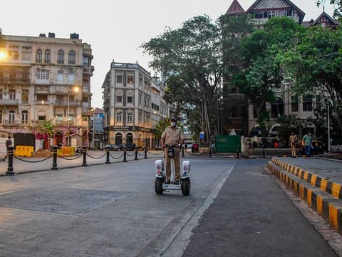 A police personnel patrols near the Gateway of India area, before the start of the 15-day curfew due to a surge in COVID-19 cases, at Colaba, in Mumbai, Wednesday, April 14, 2021.