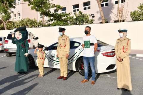 Lucas Li Chao with Dubai Police officials and the Dubai Police mascot.