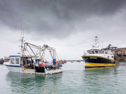 French fishing vessels block the port of St Helier in Jersey, Thursday, May 6, 2021. French fishermen angry over loss of access to waters off their coast have gathered their boats in protest off the English Channel island of Jersey.