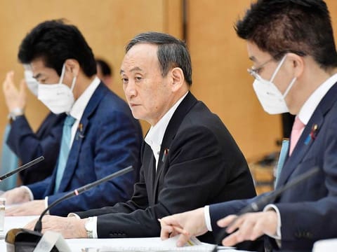 Japanese Prime Minister Yoshihide, centre, attends a meeting on the COVID-19 infections at the prime minister's office in Tokyo Friday, May 7, 2021.