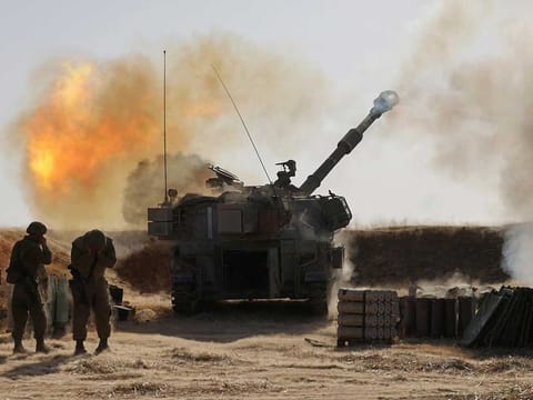 Israeli soldiers fire a 155mm self-propelled howitzer towards targets in the Gaza Strip from their position near the southern Israeli city of Sderot on May 12, 2021.
