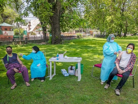 Health workers administer Covishield, Serum Institute of India's version of the AstraZeneca vaccine as they inoculate people against COVID-19 at a park in Srinagar, J&K, India