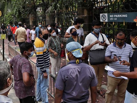 People line up to receive vaccine for COVID-19 outside a vaccination centre in Mumbai, India, Saturday, May 29, 2020.