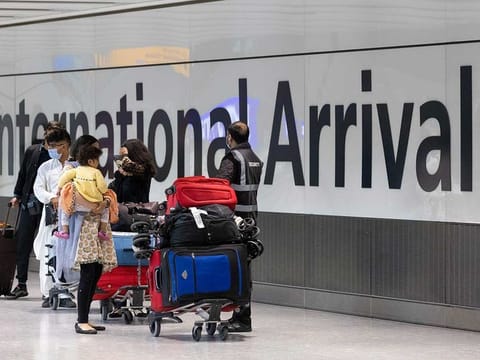 Passengers, wearing protective face masks, walk through the international arrivals hall after arriving in Terminal 5 at London Heathrow Airport in London, UK, on Monday, May 17, 2021.