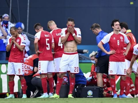 Denmark players react while medics assist Christian Eriksen after he collapsed on the pitch during the Euro 2020 match against Finland