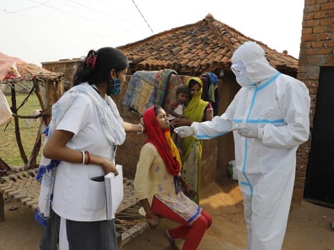 Health workers take nasal swab of a woman to test for COVID-19 in Jamsoti village in Uttar Pradesh.