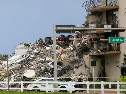 A police car is parked in front of debris from a partially collapsed building in Surfside north of Miami Beach, on June 24, 2021.