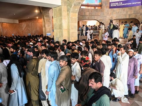 People, including overseas Pakistani workers, who want to fly to the Middle East stand in a queue to register before receiving a dose of the Pfizer Covid-19 vaccine at a vaccination centre in Islamabad on June 28, 2021.