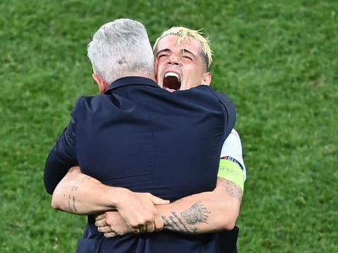 Switzerland’s Granit Xhaka embraces coach Vladimir Petkovic as they celebrate beating France on penalties.
