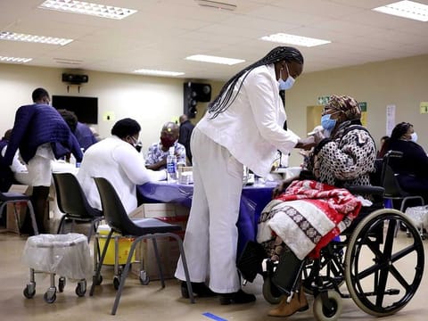 A woman receives a dose of a coronavirus disease (COVID-19) vaccine, as South Africa rolls out vaccination to the elderly at the Munsieville Care for the Aged Centre outside Johannesburg, South Africa May 17, 2021.