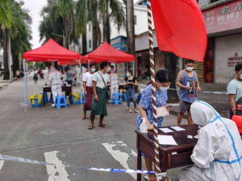 People queue to undergo nucleic acid testing in the city of Ruili which borders Myanmar in China's southwestern Yunnan province on July 5, 2021.
