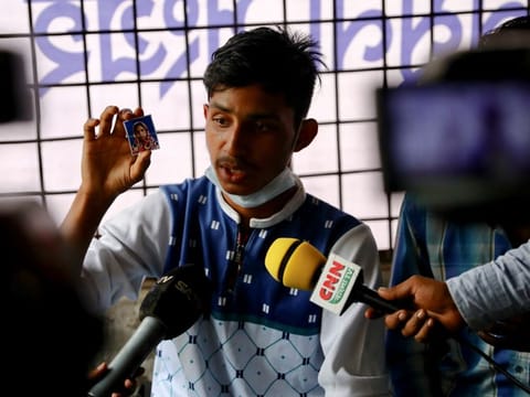 A man shows a picture of his mother who is missing after a fire broke out at a Hashem Foods Ltd factory in Rupganj, Narayanganj district, on the outskirts of Dhaka, Bangladesh, July 10, 2021.