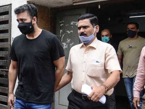 Mumbai Police's Crime Branch team escort Bollywood actress Shilpa Shetty's husband Raj Kundra (L) for allegedly producing and broadcasting pornographic films online, in Mumbai on July 27, 2021.